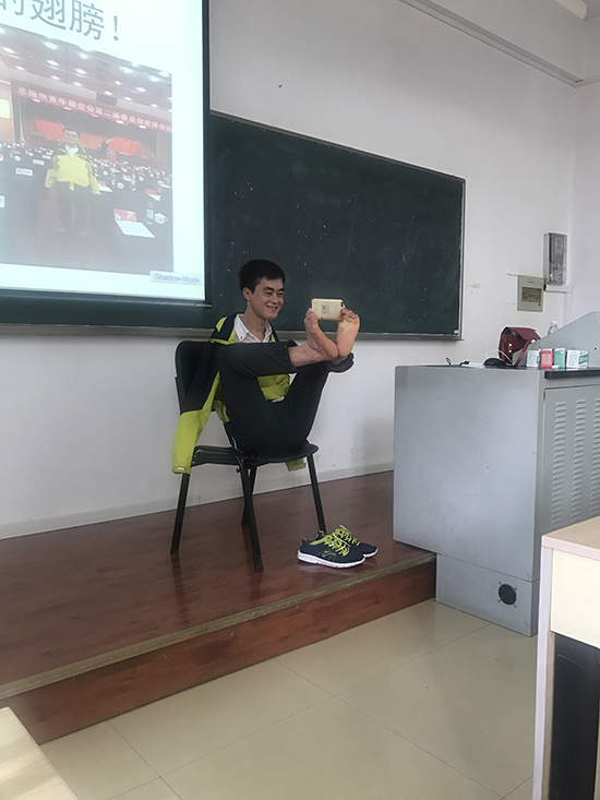 1521213135427083483.jpg 陈兹方用脚为学生照相(黄天蔚拍摄).jpg